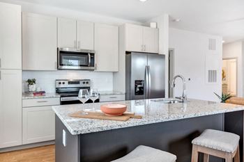 Kitchen with granite countertops, soft-close cabinets, and stainless steel appliances at anthem luxury rentals and apartments in huntsville, al